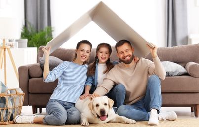 Familie mit Hund zu Hause im Wohnzimmer